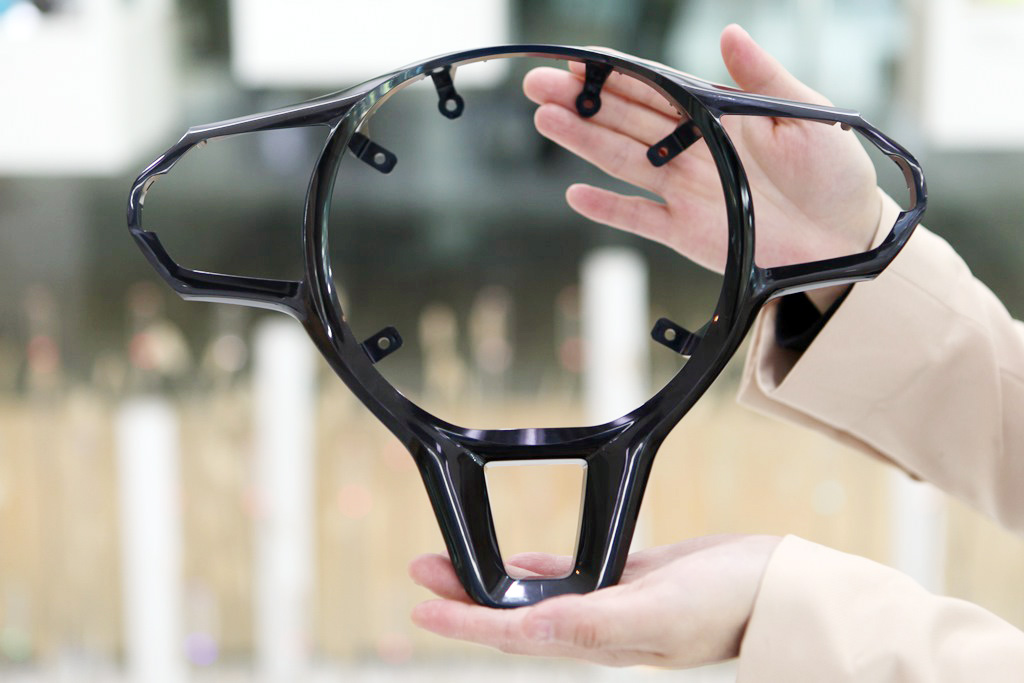 SK케미칼 구성원이 PETG/ABS 컴파운드 소재가 적용된 스티어링 휠 베젤을 선보이고 있다.